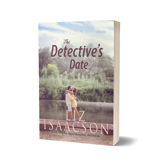 Book cover of 'The Detective's Date' by Liz Isaacson with a couple embracing by a lake.