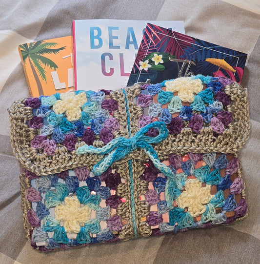 Colorful crocheted bag with a bow on a textured surface