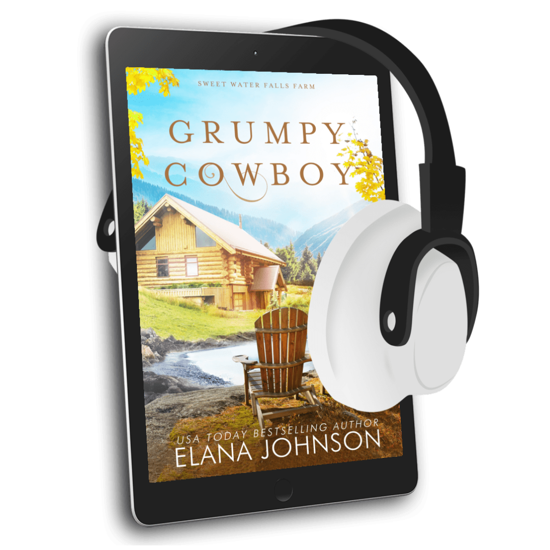 A tablet displaying the book cover of 'Grumpy Cowboy' by Elana Johnson, with white and black over-ear headphones floating beside it on a white background.