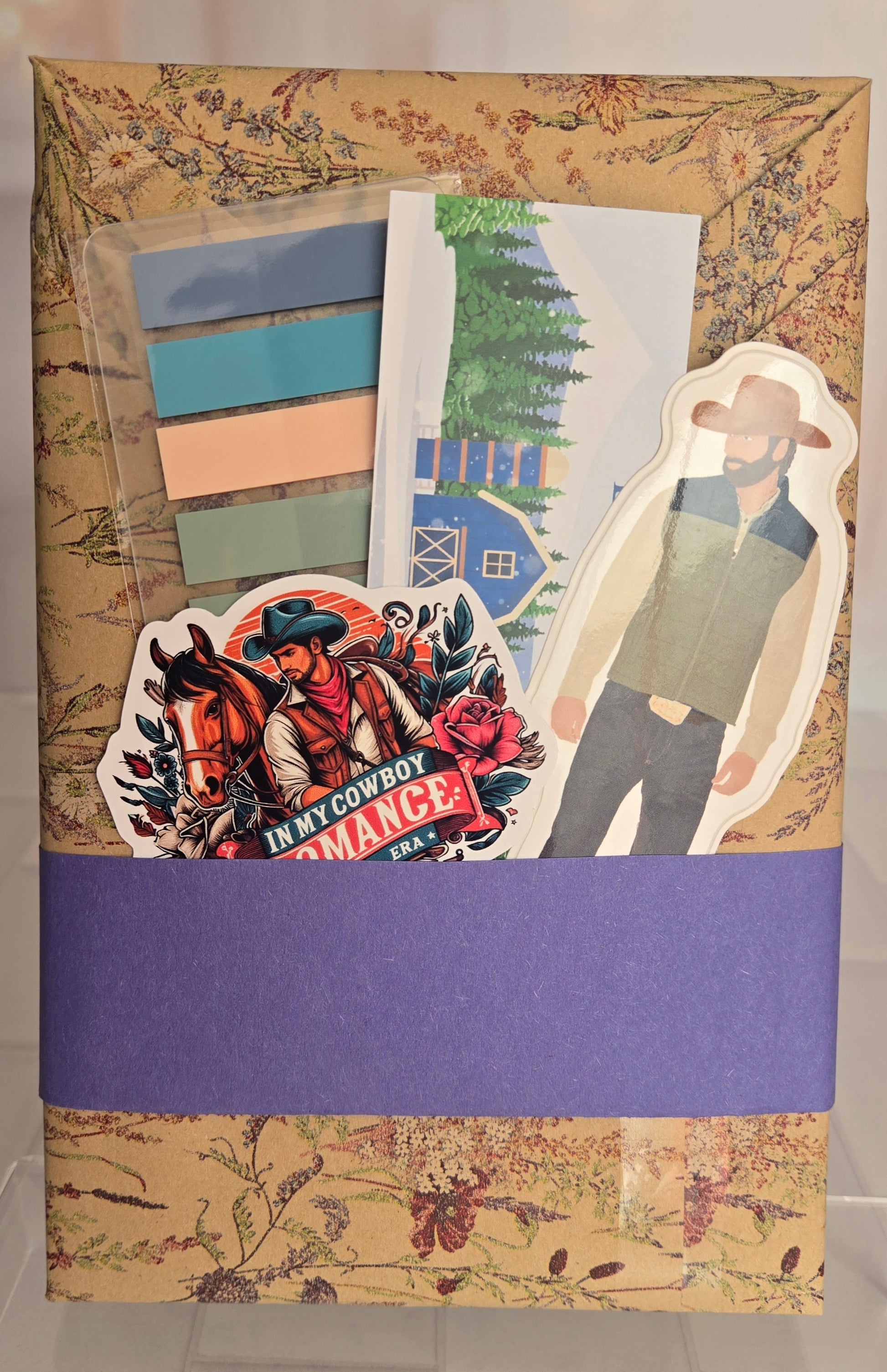 Decorative book cover with cowboy-themed illustrations and a purple band
